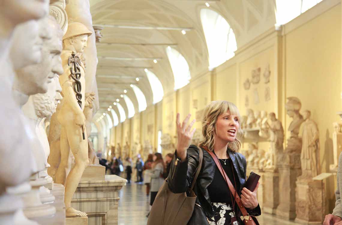 A tour guide explaining the statues in the Vatican museum on a private tour.