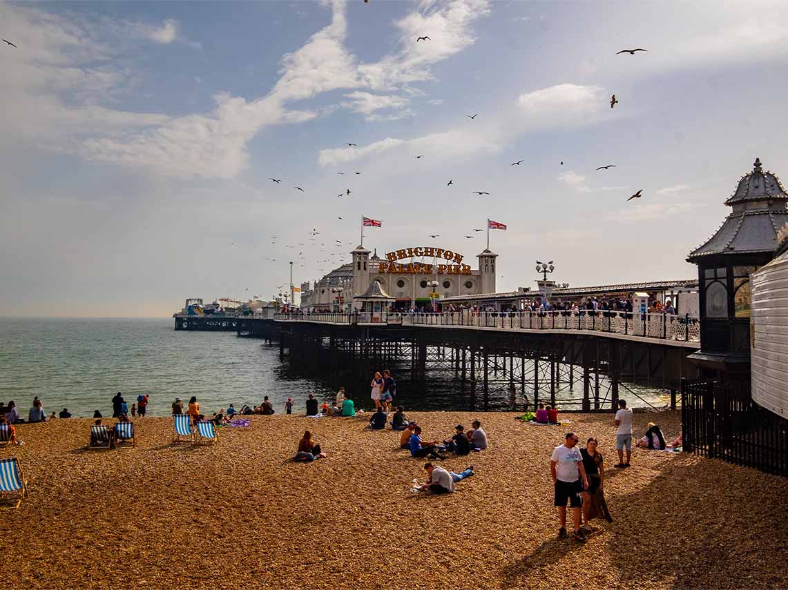 Guests on tour enjoying the beach at Brighton Pier.