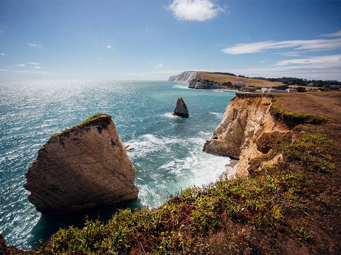 Driver guide and clients on tour visiting the coast of the Isle of Wight.